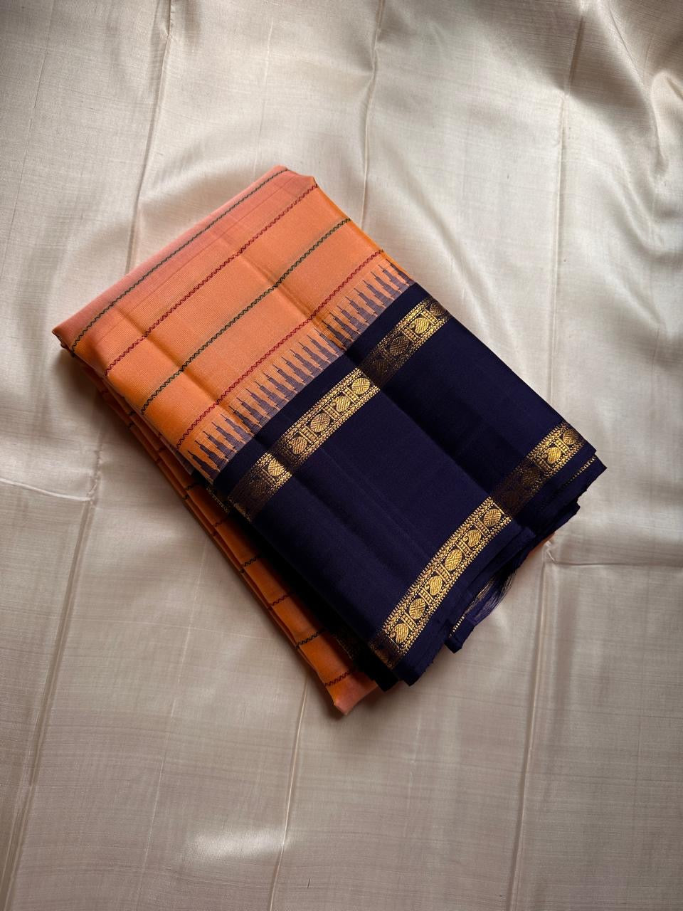 Peach Veldhari ✨ – Pure Kanchipuram Silk Saree with Royal Blue Border & Pallu

Peach-Orange Veldhari Striped Body with Subtle Green & Maroon Accents

Royal Blue Korvai Border with Intricate Gold Zari Motifs

Majestic Royal Blue Zari Brocade Pallu