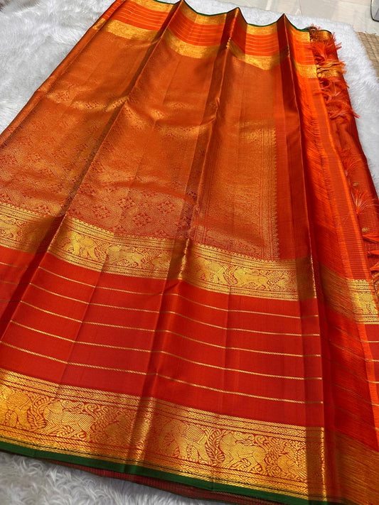 Kiran orange red oosi kattam  ✨ – Fiery Orange Kanchipuram Pure Silk Saree
Korvai Gold Zari Border with Elephant & Floral Motifs
Body Woven in Zari Kattam Checks with Scattered Gold Buttas
Grand Zari Brocade Pallu | Silk Mark Certified |