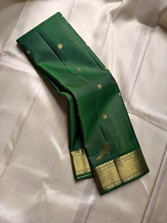 Kili Green ✨
Vairaoosi Pure Silk Kanchipuram Saree
Adorned with graceful Kili (parrot) motifs
Vanki Neli Border with Arai Maadam & Rudhraksham Pet
Opulent Grid Zari Weave with Green Vairaoosi Blouse fabric