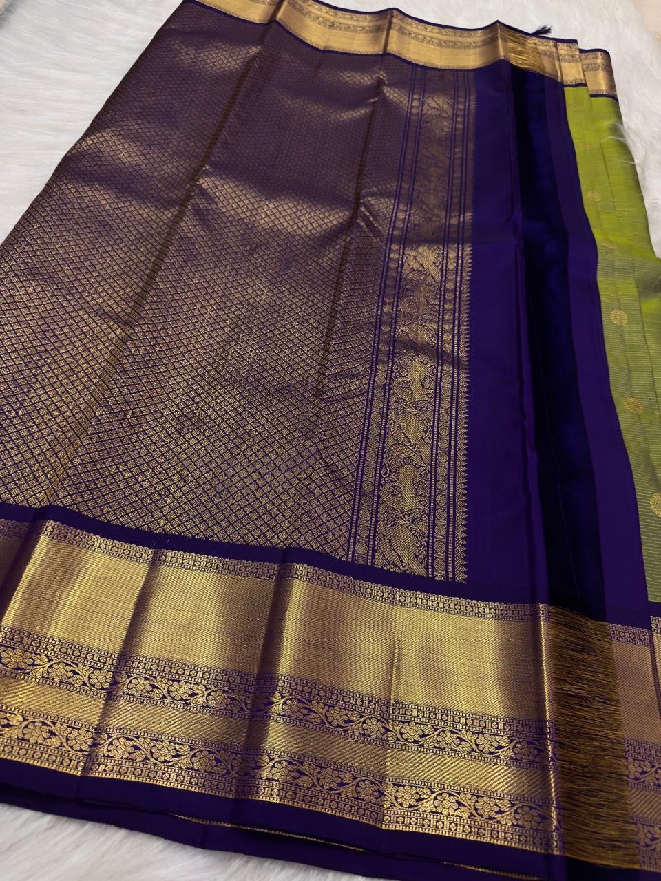 Olive green Kancheepuram Vairaoosi silk saree folded, showing purple border detail
