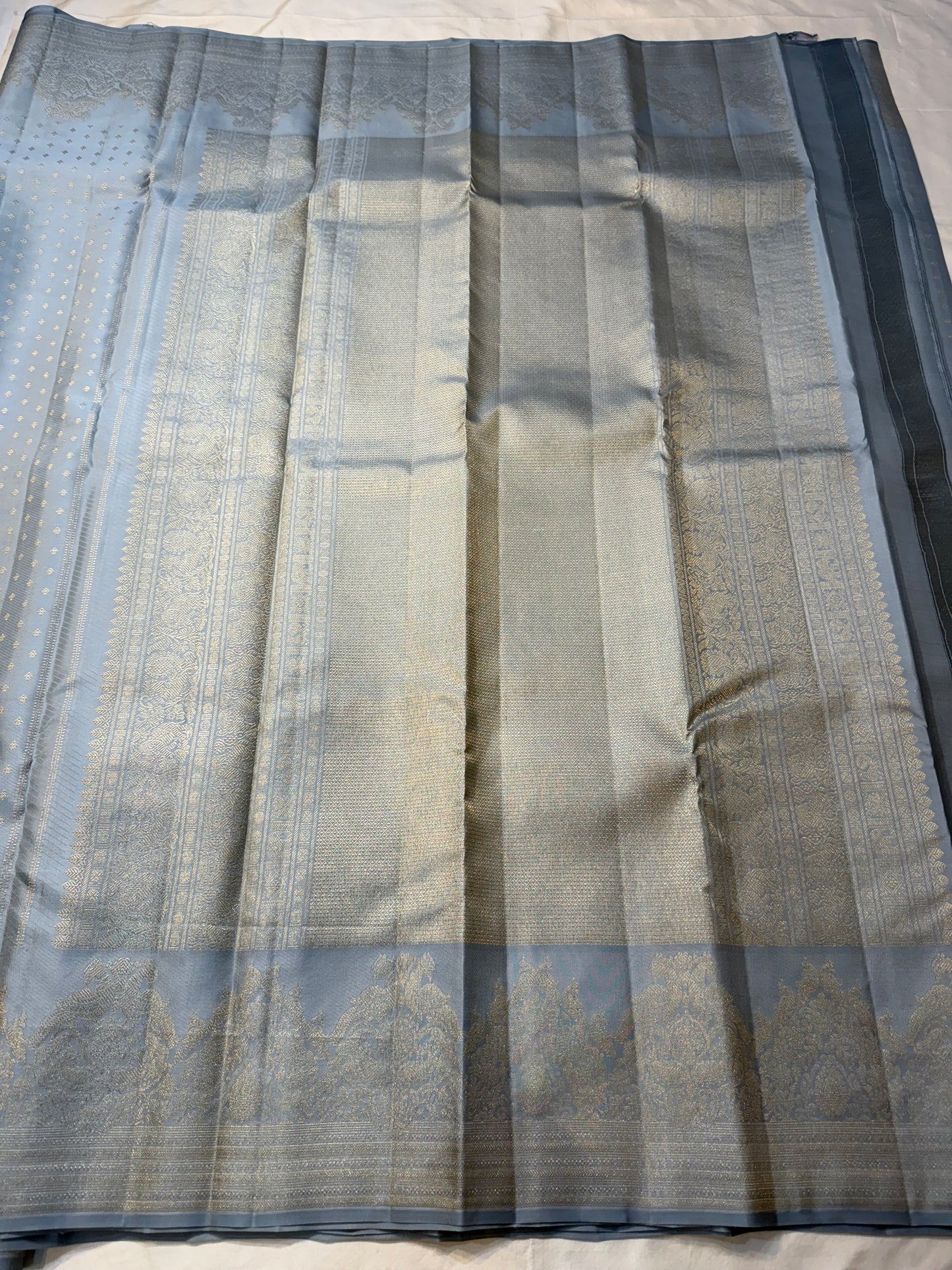 Chamomile — Kanchipuram Pure Silk

Pale gray-blue body with silver roopa buttas all over

Temple gopuram-inspired zari borders in luminous silver

Rich silver brocade pallu with intricate detailing

Silk Mark Certified • Free Shipping within USA