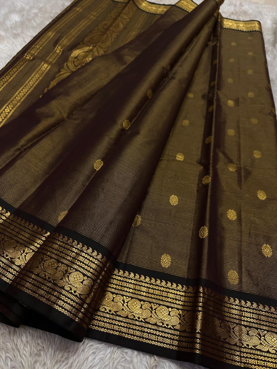 Kohl Swarna — silk mark certified lightweight saree 
Deep kohl brown body with fine pinstripes and gold rosette buttas, framed by antique-gold zari borders and grand paisley brocade pallu• free shipping eithin usa  two weeks