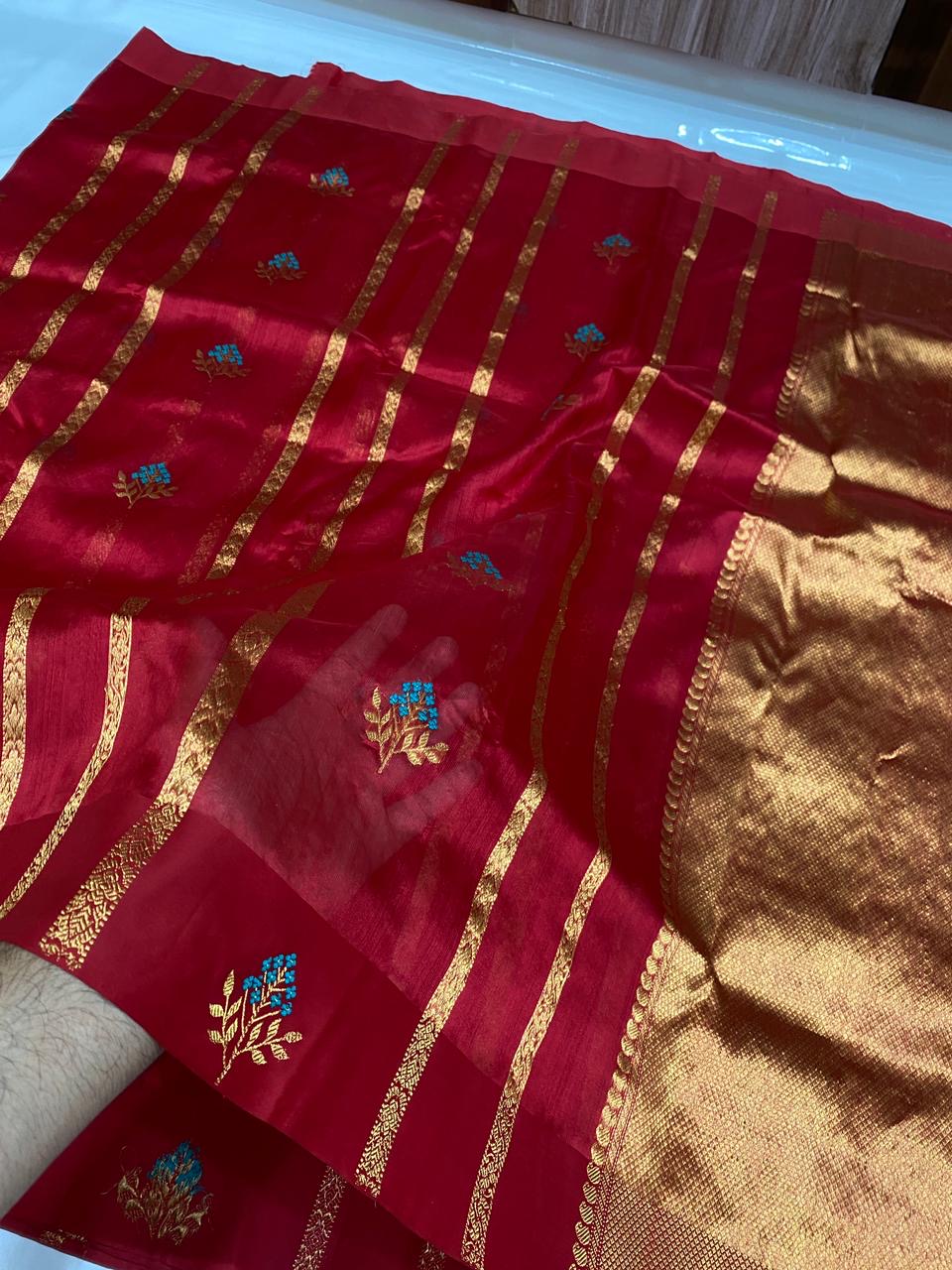 Close view of Raspberry Red Chanderi silk saree with turquoise-and-gold floral woven buttas