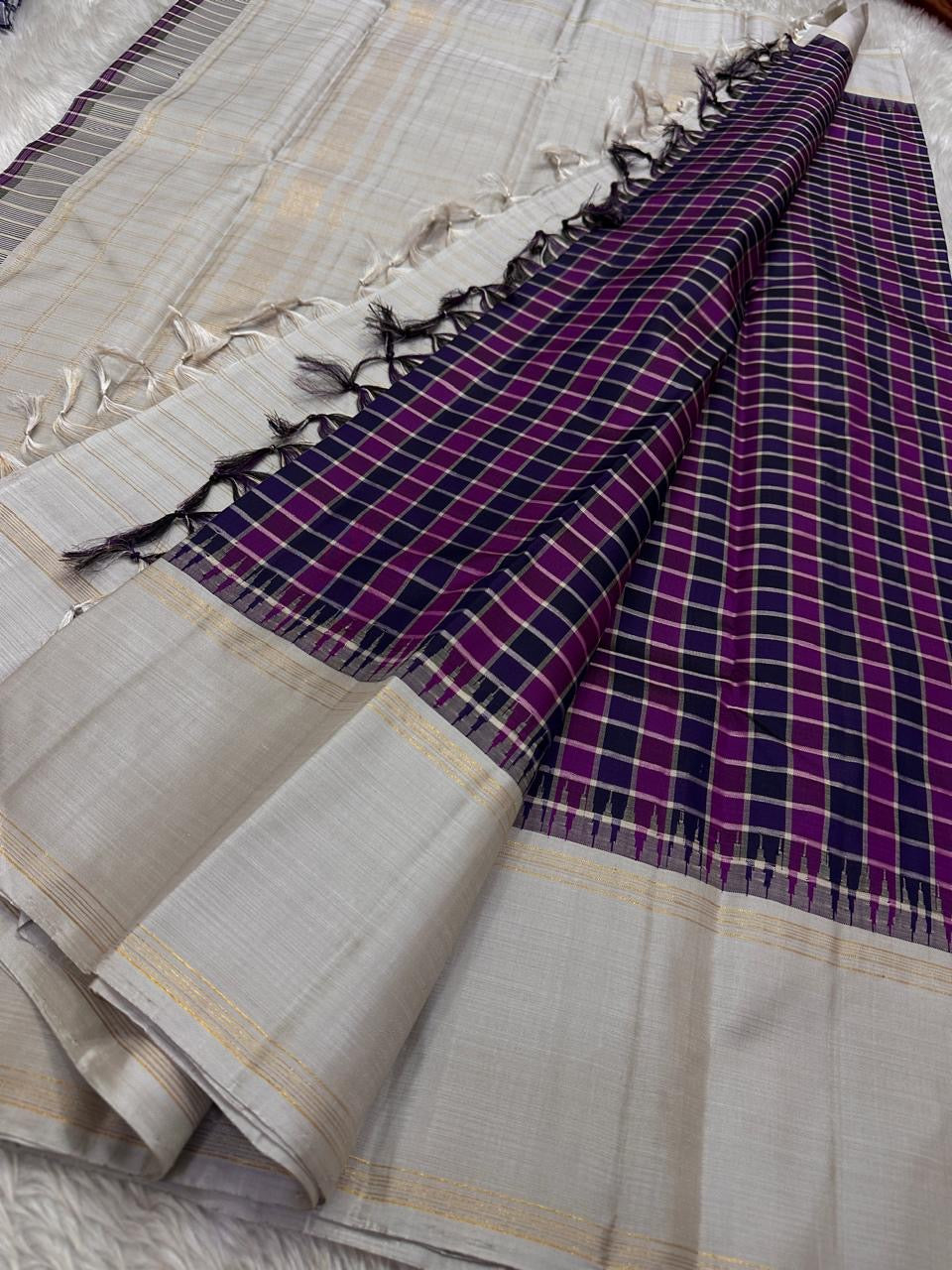 Nirai Navy - A Jewel Toned Checkered pure silk Kanchipuram saree in navy, purple, magenta, and grey checks.Accented with a soft silver-grey border and zari-striped seer pallu
Includes a silver blouse fabric with gold zari stripes