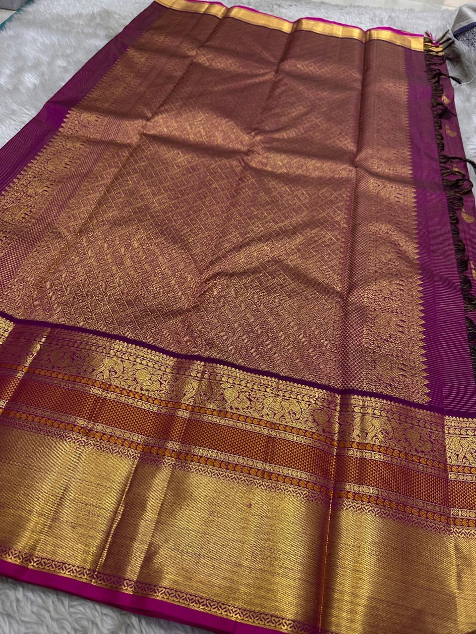 Full pallu of magenta Kanchipuram silk saree with intricate allover gold zari design and broad border