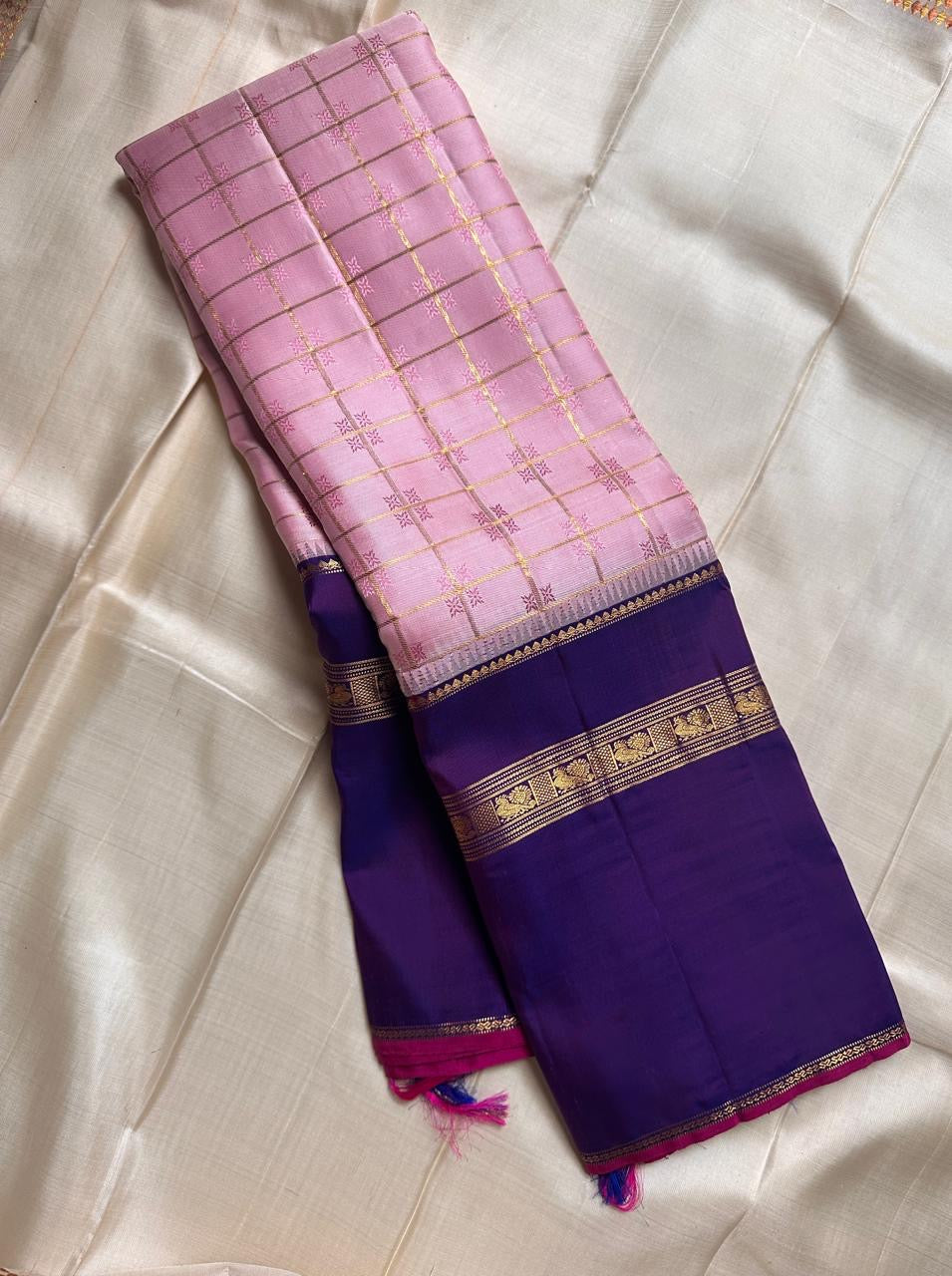 Anaar ✨ – Royal Purple & Lotus Pink Kanchipuram Pure Silk Saree
With Zari Kattam Checks, Mayil Motif Border & Grand Pallu
Korvai Contrast Weave in Regal Purple , 
Peacock & Floral Zari Panels, Raspberry Selvedge Finish
Silk Mark Certified