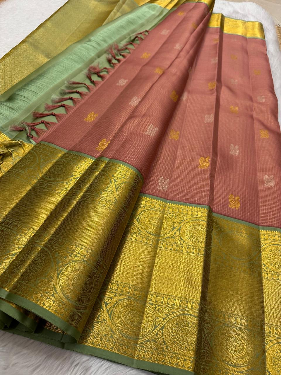 Vahini – Pleasant Peach Pink Pure Kanchipuram Silk Saree with Zari Kattam Checks, Silver & Gold Peacock Buttas, Sage Green Border Adorned with Kamalam Vines and Baavanji Motifs, and an Ornate Zari Pallu with Majestic Peacocks