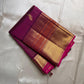 Magenta pinstriped Kanchipuram silk saree with scattered peacock buttas and wide gold zari border, draped on ivory silk