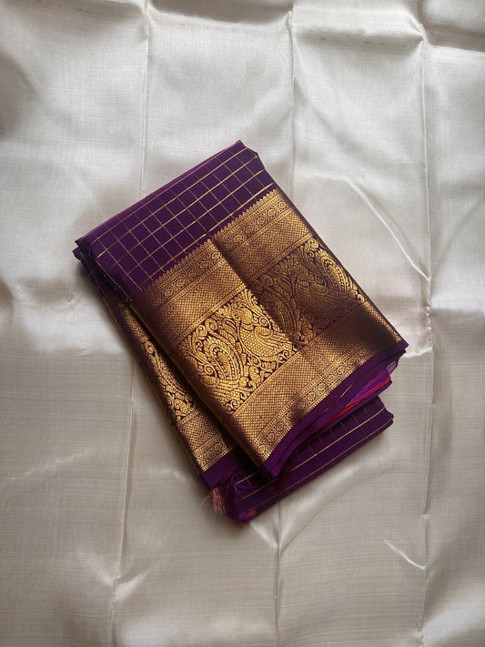 Aubergine Amber Kattam – Pure Kanchipuram Silk Saree
Deep Aubergine Purple Body with Gold Kattam Checks
Grand Zari Borders with Majestic Peacock Motifs
Contrast Amber-Orange Pallu with Rich Zari Detailing
Silk Mark Certified | ships in two weeks
