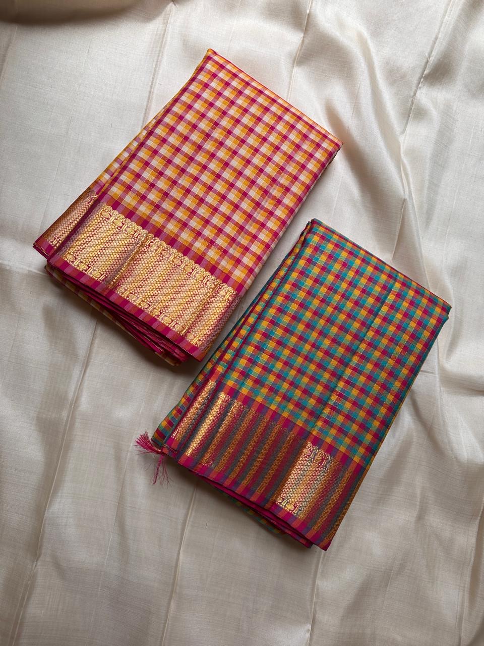 A classic Kanchipuram in Pattani Kattam checks with green, magenta, mustard, and cream.
Finished with a contrast pink border and pallu.
Paisley and chakram motifs in a graceful grid add timeless charm.