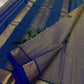 Varnam – Dove Tail Gray & Peacock Blue Kanchipuram Silk Saree. Featuring rich gold paisley buttas, a bold chevron zari border, and pure handloom silk craftsmanship ✨ Silk Mark Certified | Blouse Stitching Available | Free USA Shipping