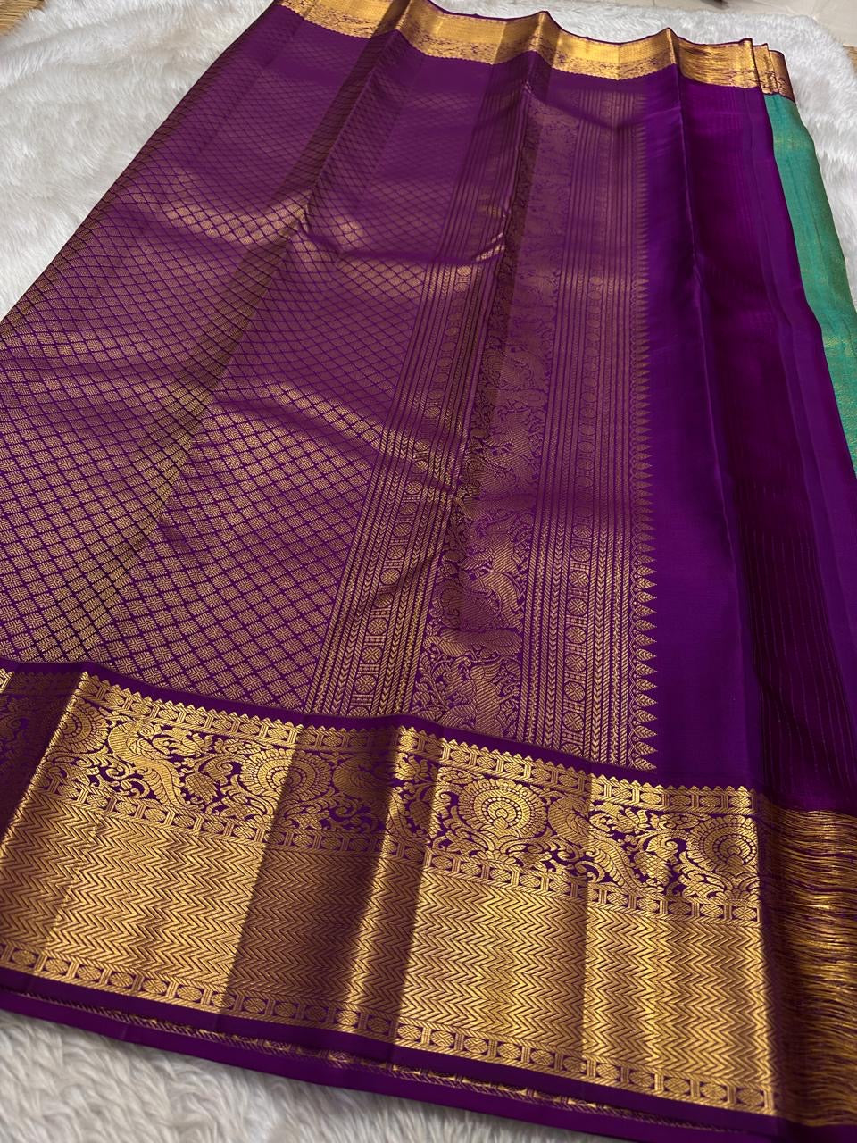 Sindhu- Teal & Purple Kanchipuram Pure Silk Saree with Floral Jaal & Mayil Border
A rich teal base adorned with delicate floral jaal and regal purple mayil borders creates timeless elegance. The diamond-motif pallu adds a bold, sophisticated finish to th
