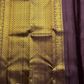 Tanaya features a regal mulberry mauve purple body adorned with golden kamalam and mayil buttas. Its elegant dual-tone border—coffee brown on top and emerald green below with rich temple-inspired zari work with medallions and florals woven, rich Pallu.