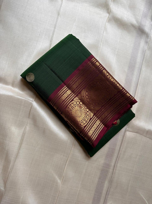 Pachai Butta – Pure Kanchipuram Silk Saree
Emerald silk scattered with radiant buttas.
A wine korvai border rich in gaja artistry.
Floral medallions glow in antique-gold zari.

Silk Mark Certified, delivery in 2 weeks