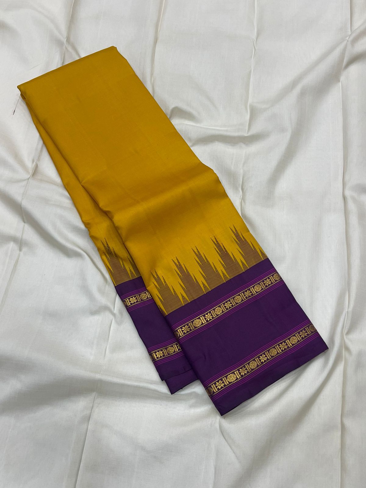 Suvarna Nitya
Mustard–Purple Kanchipuram Silk Saree
Heritage Temple Reku • Gold Zari Borders • Silk Mark Certified