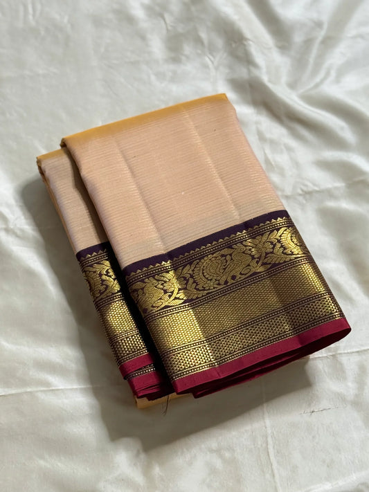 Sandhya 🌅 – Sun-Kissed Beige Kanchipuram Silk Saree with Subtle Vairaoosi Gold Filament ✨, Deep Purple Peacock Diamond-Pettu Zari Border 🦚, Deep Maroon Selvedge, and Zari-Embellished Pallu with Arai Maadam & Khalasam Motifs 🌿💛