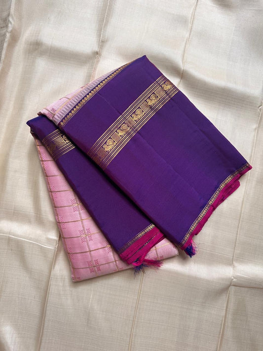 Anaar ✨ – Royal Purple & Lotus Pink Kanchipuram Pure Silk Saree
With Zari Kattam Checks, Mayil Motif Border & Grand Pallu
Korvai Contrast Weave in Regal Purple , 
Peacock & Floral Zari Panels, Raspberry Selvedge Finish
Silk Mark Certified