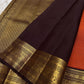 Kavi — oosi  kattam Pure Kanchipuram Silk Saree

Burnt Orange (saffron–rust) body
Deep coffee-maroon contrast border with grand antique-gold zari
Rich brocade pallu; peacock & floral vines in the border
Silk Mark Certified