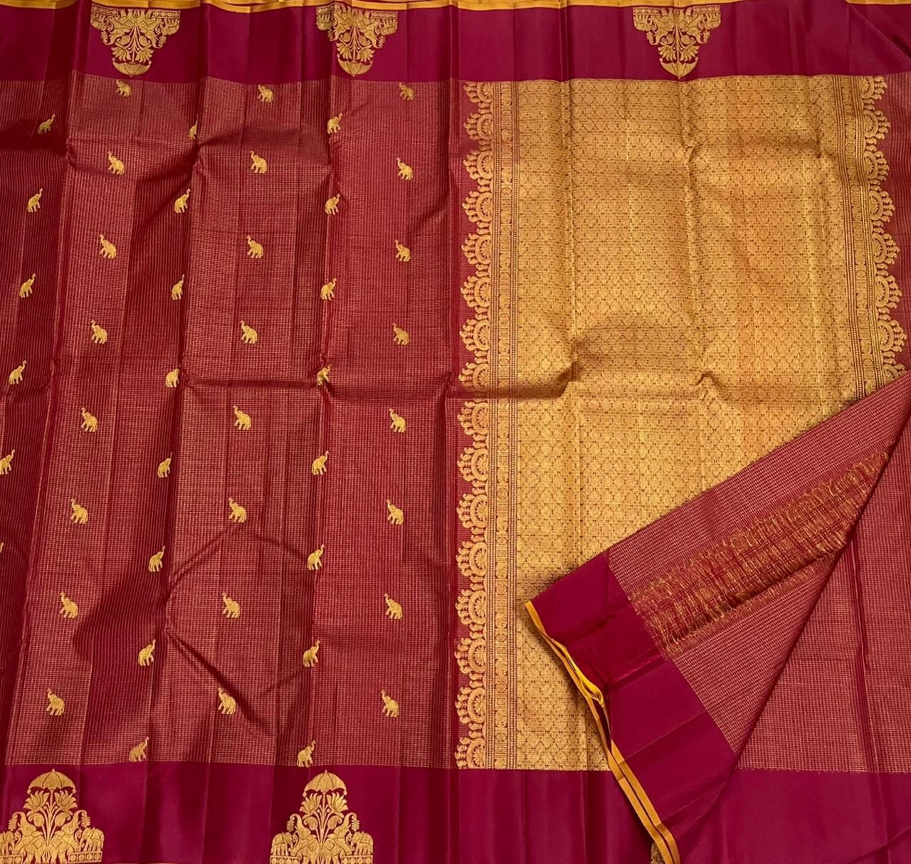 Full view of maroon vairaoosi zari kattam saree with scattered gold elephant buttas, wine border, and gold zari pallu.