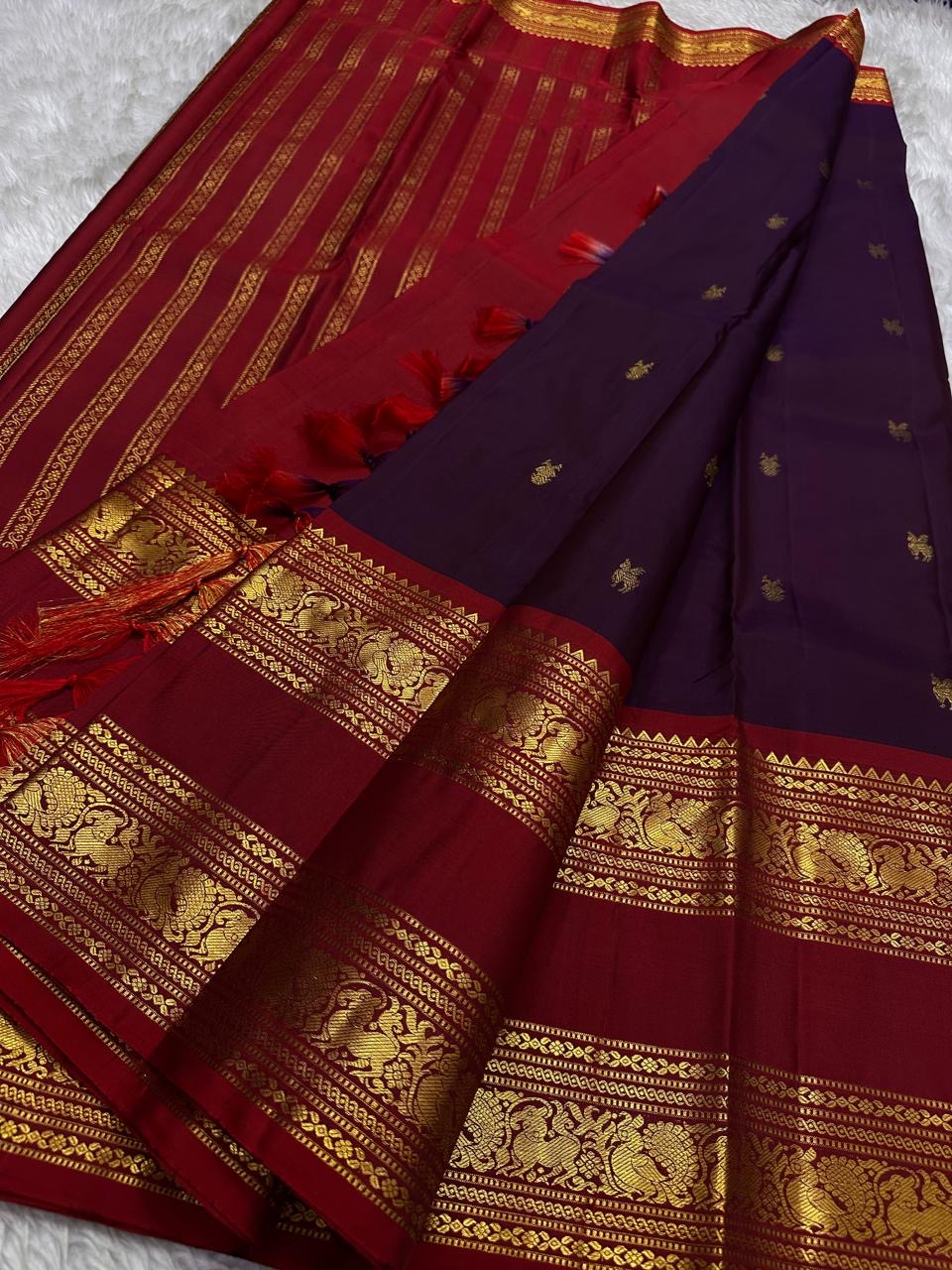 Purnima ✨ – Kumkum-Red & Aubergine Kanchipuram Pure Silk Saree
With Zari Winged Horse Buttas on the Aubergine Body
Grand Gold Annam & Floral Korvai Border with Temple Rekku
Varisaipettu Striped Gold Brocade Pallu with Hand-Knotted Tassels
Silk Mark