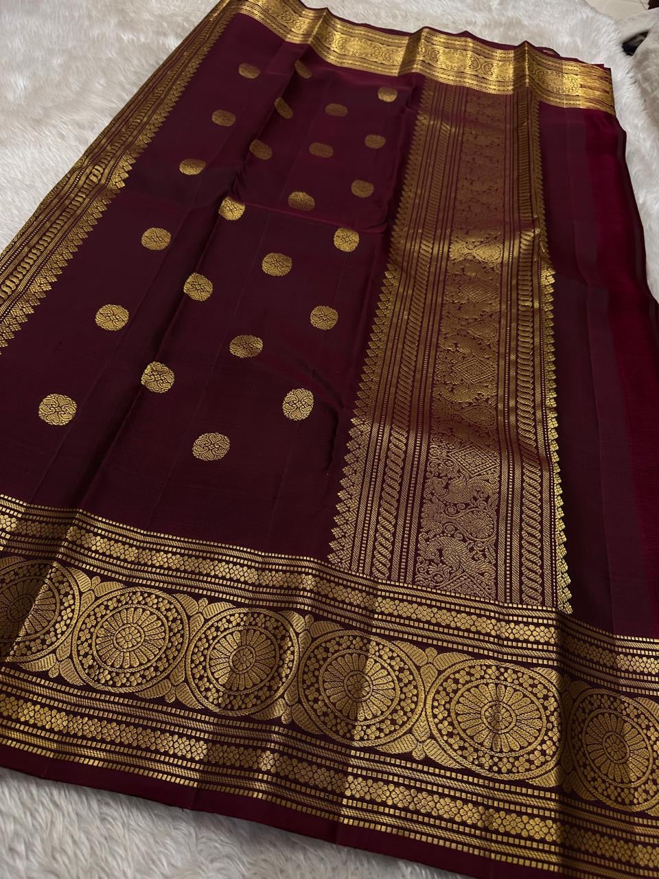 Pachai Butta – Pure Kanchipuram Silk Saree
Emerald silk scattered with radiant buttas.
A wine korvai border rich in gaja artistry.
Floral medallions glow in antique-gold zari.

Silk Mark Certified, delivery in 2 weeks