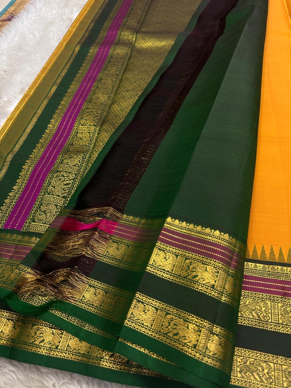 Lakshanam ✨ – Maambazha (Mango) Yellow Kanchipuram Pure Silk Saree
Korvai Deep-Green Border with Yazhi, Peacock & Elephant Varisaipet Panels
Temple-Tip Inner Edge & Rani-Magenta Accent Stripes
Intricate Zari-Weave Green Pallu with Chevron & Stripes