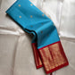 Sky blue silk saree body with small gold buttas and rich red zari woven border