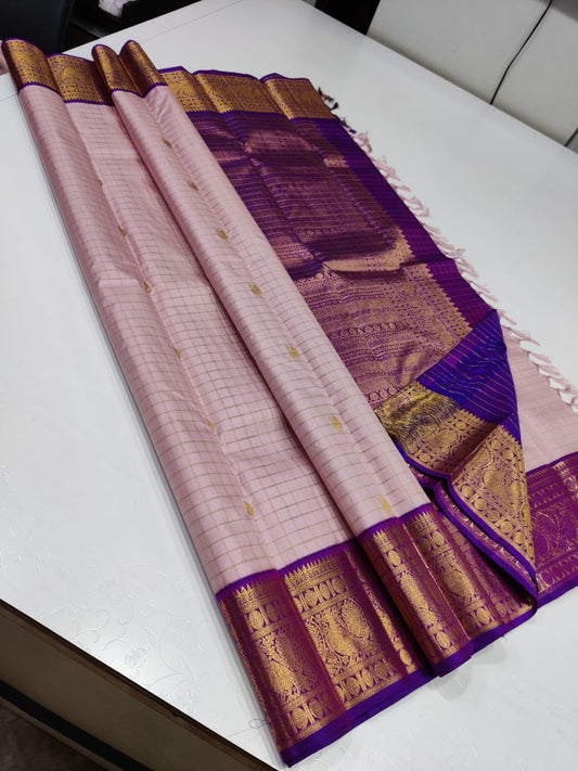 Gilded Blush

 Blush Pink Kanchipuram Pure Silk Saree

All-Over Gold Zari Kattam Weave with Buttas

Royal Purple Border with 2G Zari Peacock Motifs

Grand Purple Brocade Pallu | Contrast Blouse fabric 

 Silk mark certified pure silk , 2G Zari