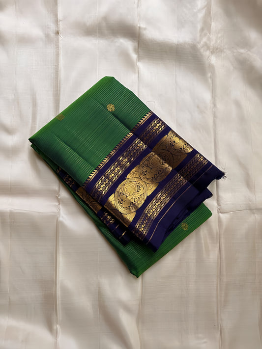 Pure silk adarpachai forest green  with royal blue zari lines all over , peacock motifs border and royal blue detailed Pallu