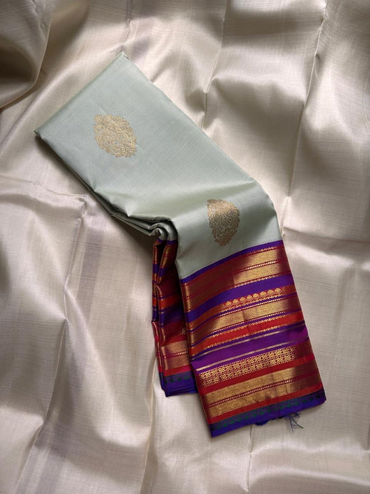 Kumari ✨ – Pastel Sage Green Kanchipuram Pure Silk Saree
with Delicate Golden Floral Buttas 🌸
Purple–Red Korvai Varisaipet Zari Border
Grand Purple Pallu with Stripes & Floral Vines
An Heirloom of Grace, Heritage & Festive Splendor