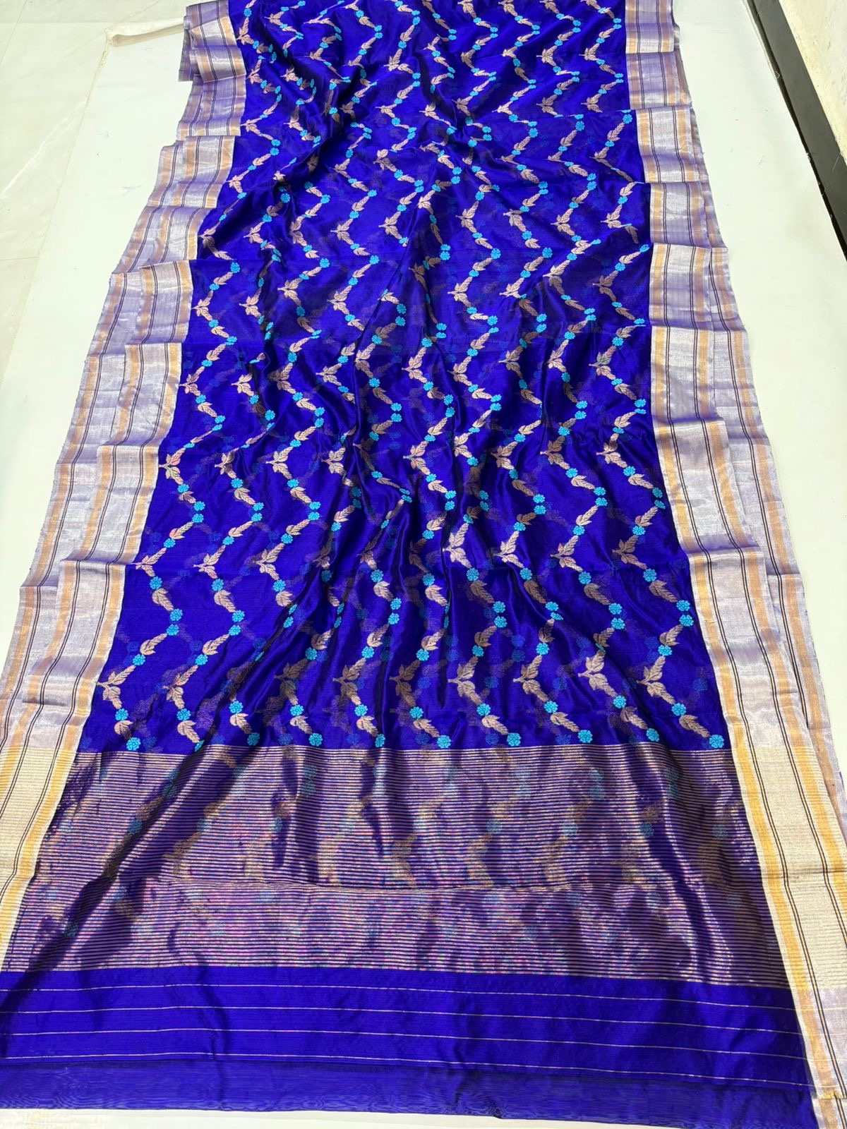 Pure Silk Chanderi Saree in Royal Blue with Teal–Gold Floral Vine Motifs
Silver–Gold Tissue Borders with Subtle Striped Pallu
Fall & Pico Done • Blouse Stitching Available ($30) • Free Shipping within USA • Ships in Two Weeks