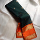Nirupama ✨ – Bottle-Green Kanchipuram Pure Silk Saree
With Striking Saffron-Orange Korvai Contrast Border rettapet 
Adorned with Gold Rosette Buttas & Medallion Bands
Grand Zari Brocade Pallu in Cascading Motifs