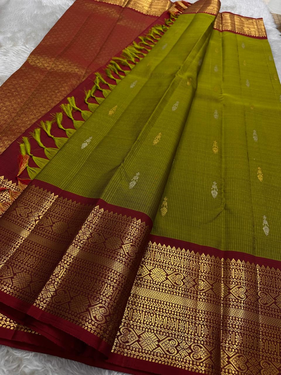 Golden Emerald Gleam ✨ – Pure Kanchipuram Silk Saree
Parrot Green & Turmeric Shot with Gold & Silver Leaf Buttas 🌿
Crimson Red Korvai Border with Temple Peaks  ❤️
Grand Crimson Pallu 🌟

Silk Mark Certified, delivery in 2 weeks