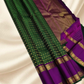 An heirloom-worthy drape woven in the finest 2G pure silk, this traditional Kanchipuram saree brings together the timeless beauty of zari buttas and checks in a rich green body. The contrast purple  rettapet border stands bold and elegant