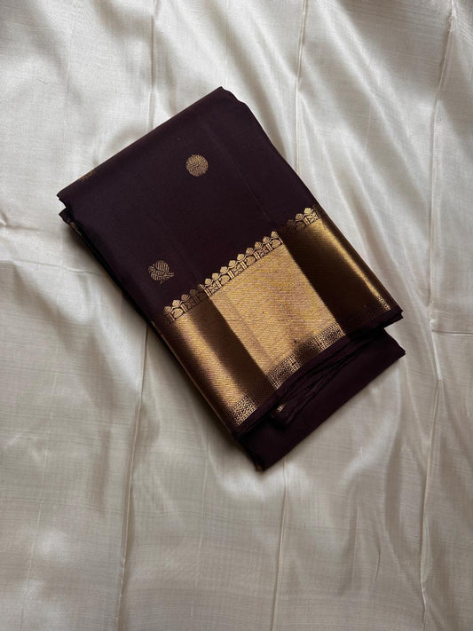 Agnika – Dark Espresso Kanchipuram Silk Saree with Mayil Chakram Butta
Fiery and regal, Agnika features a rich dark espresso silk body with intricate Mayil Chakram (peacock) motifs and a shimmering zari border—an elegant ode to South Indian tradition.