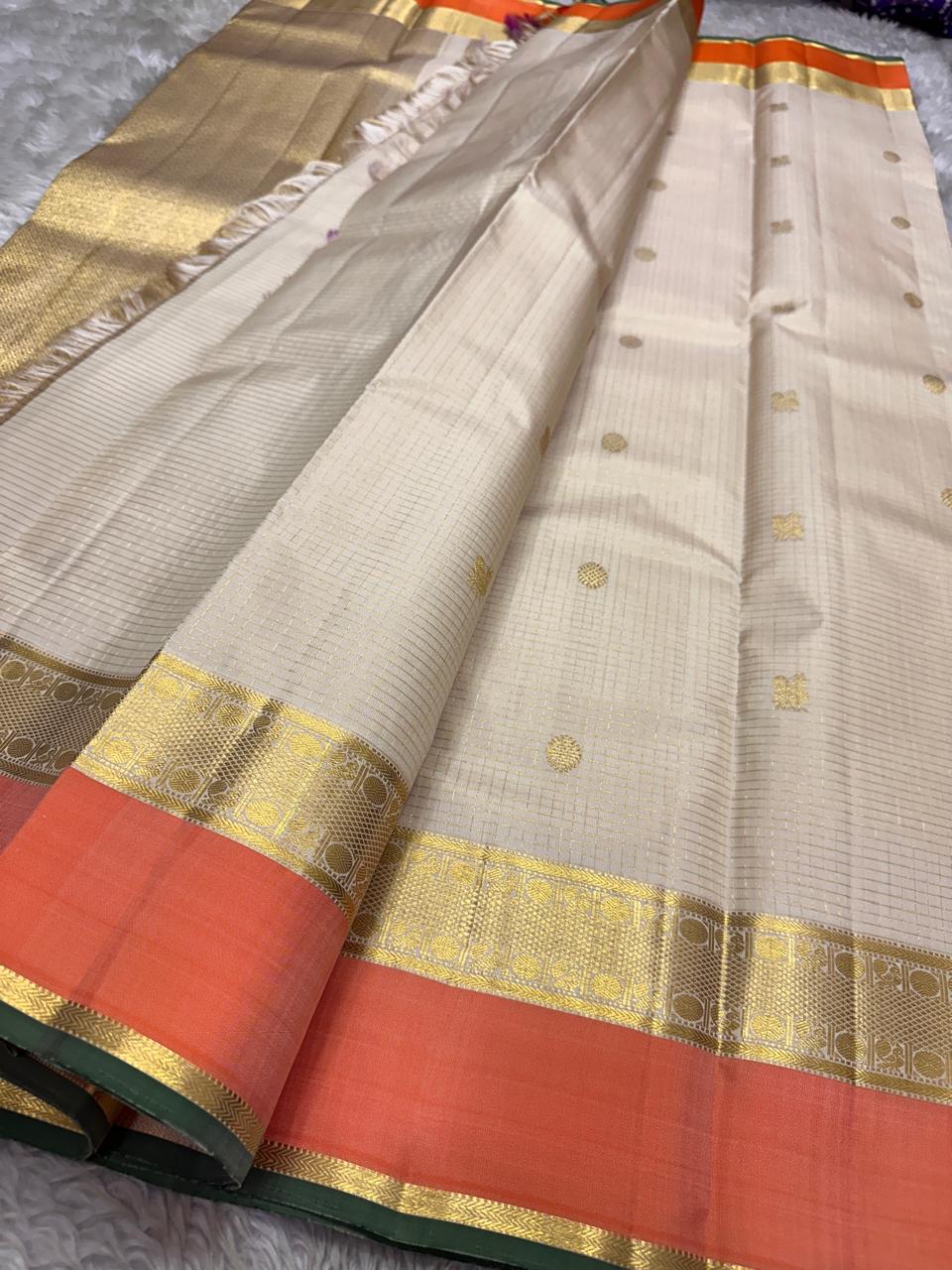 Ivory Saffron Zari Kattam | Pure Kanchipuram Silk ✨
Ivory body with zari kattam checks, gold buttas & saffron border 🍂
Silk Mark Certified • Free Shipping within USA • Ships in Two Weeks ✅
