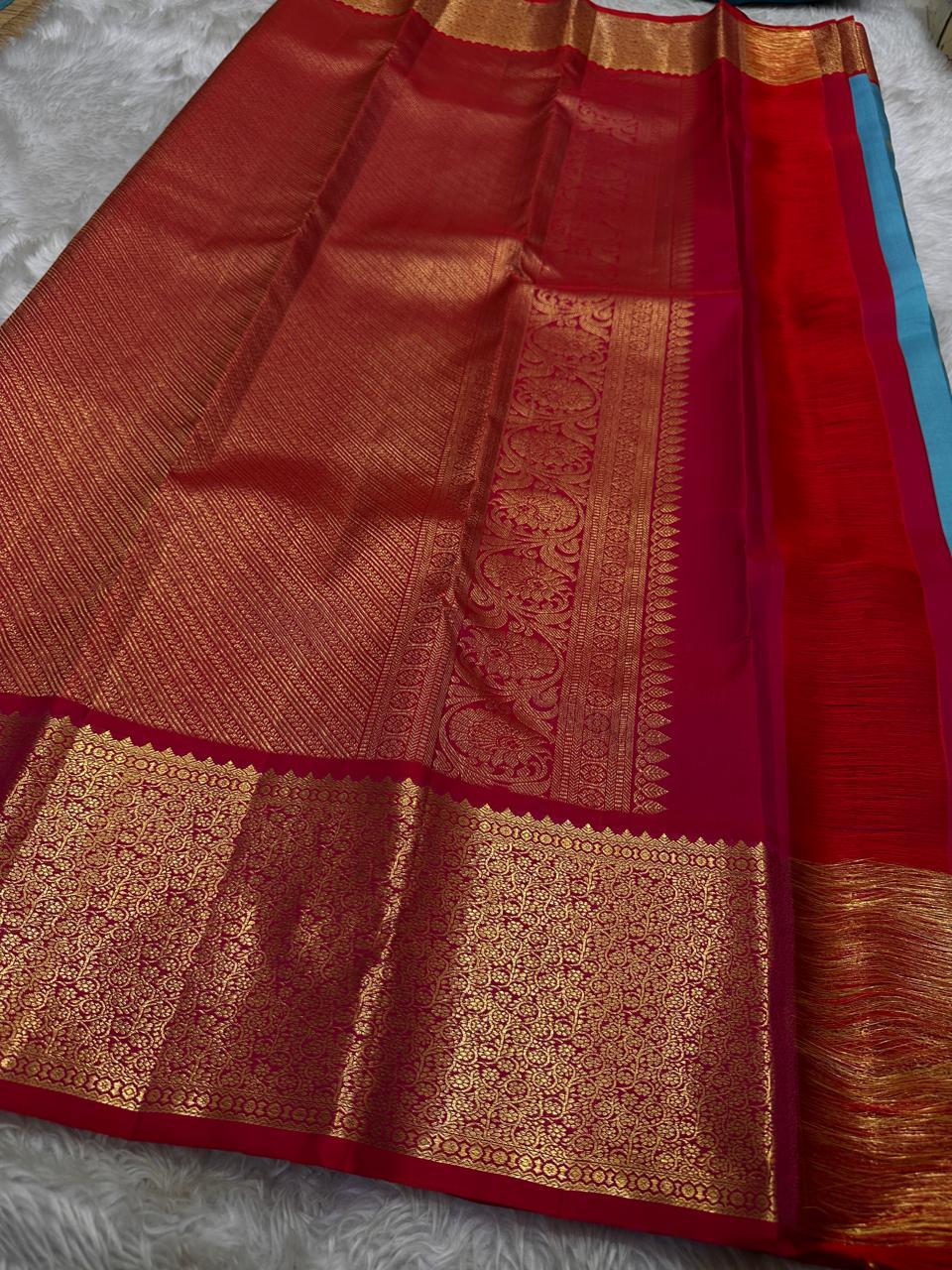 Close view of red zari woven border with dense gold pattern on Kanchipuram silk