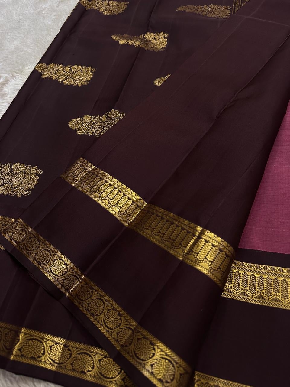 Contrast coffee pallu close-up with gold zari woven motifs and maroon body glimpse
