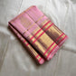 Blush pink Kanchipuram silk saree folded on ivory backdrop with gold zari checks and border – Idam Living