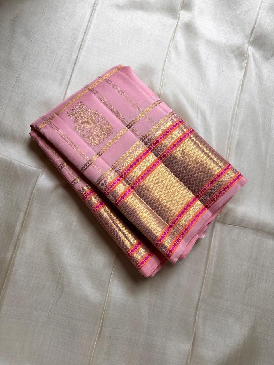 Blush pink Kanchipuram silk saree folded on ivory backdrop with gold zari checks and border – Idam Living