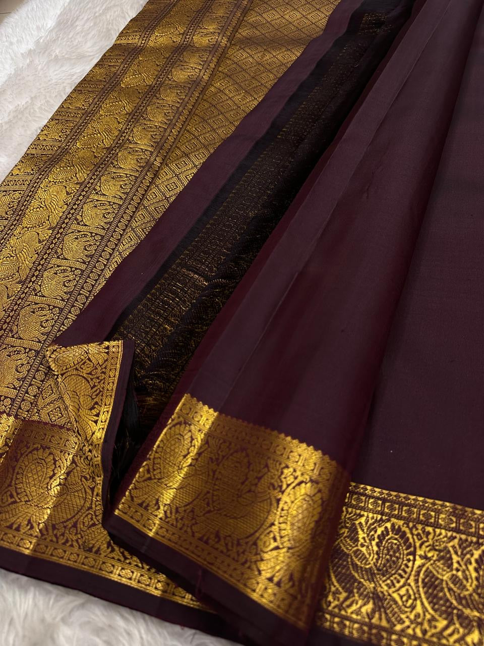Traditional Kanchipuram silk saree in deep aubergine brown with heritage Annapakshi zari craftsmanship