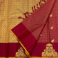 Close-up of maroon zari kattam saree with wine border and gold thiruvizha motif beside the gold zari pallu panel.