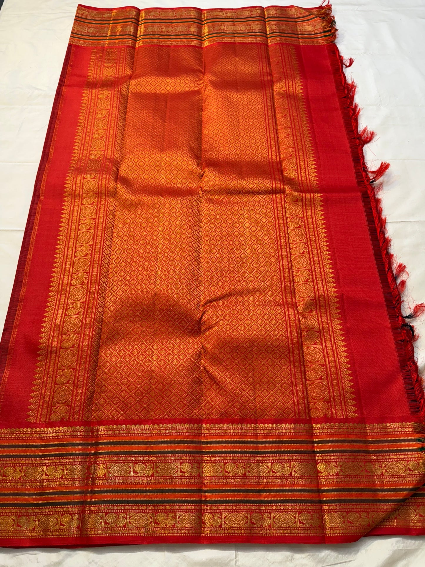Red-gold zari woven pallu spread showing diamond jaal and traditional border detailing