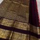 A regal  shot tomato red pink Kanchipuram silk saree features elegant chakram and mayil gold zari buttas woven across the body. Brown contrast rettapet border and Pallu vanasringaram details