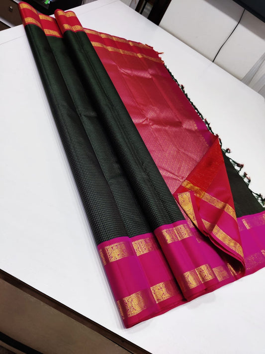 Emerald Fuchsia Zari kattam – Pure Kanchipuram Silk Saree
Zari Kattam Checks All Over the Body ✨
Rani-Pink Rettapet Border with 2G Gold Zari
Grand Brocade Pallu in Contrast Rani-Pink

Silk Mark Certified, delivery in 2 weeks