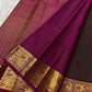Magenta-purple pallu with dense old-gold floral lattice and vertical zari panels on dark plum brown Kanchipuram saree