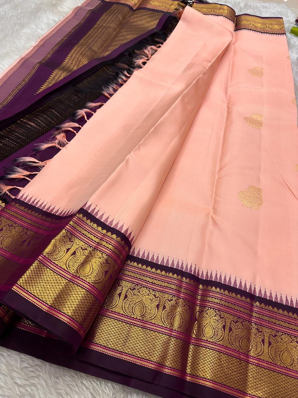 Mohana peach 🌸✨ – Graceful Peach Pure Kanchipuram Silk Saree with Handwoven Zari Peacocks 🦚, Deep Purple Peacock Border 💜🦚, Pillayar Moggu Detailing 🌺, & Intricately Woven Grid Zari Pallu 🎀💛