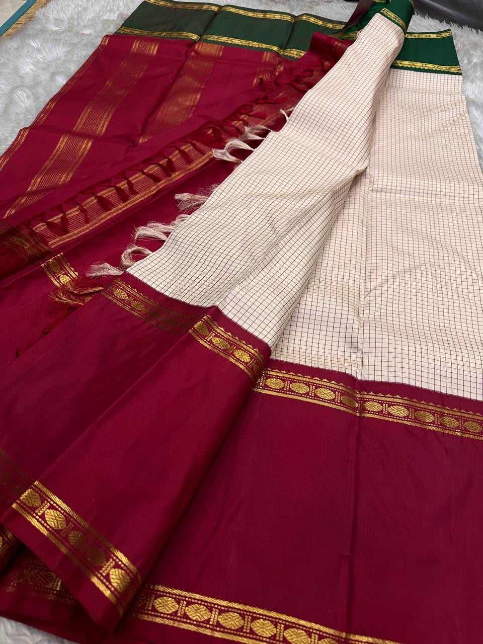 Full saree spread showing maroon pallu with gold zari stripes and tassels
