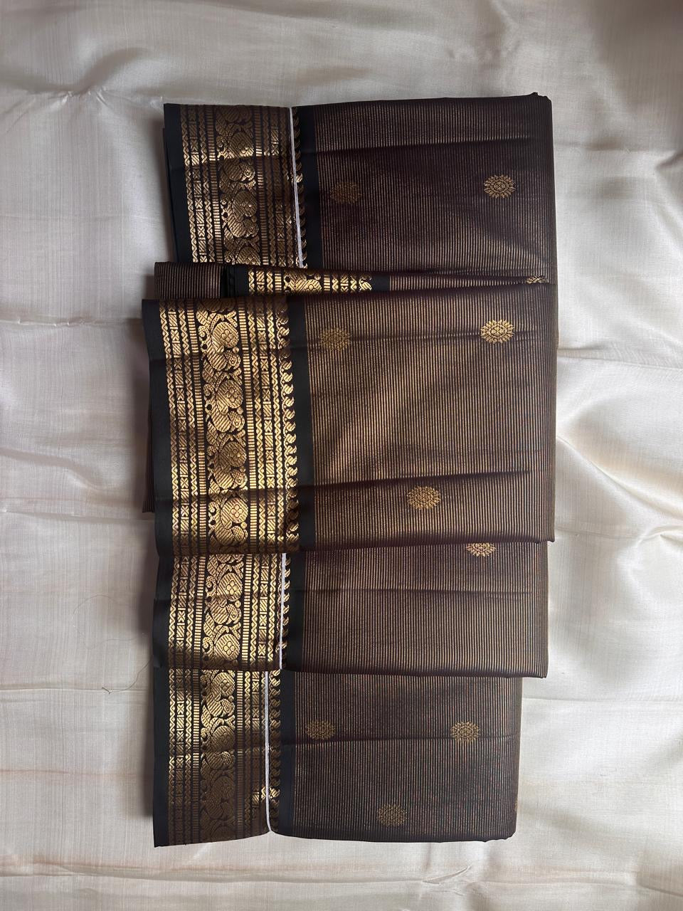 Kohl Swarna — silk mark certified lightweight saree 
Deep kohl brown body with fine pinstripes and gold rosette buttas, framed by antique-gold zari borders and grand paisley brocade pallu• free shipping eithin usa  two weeks