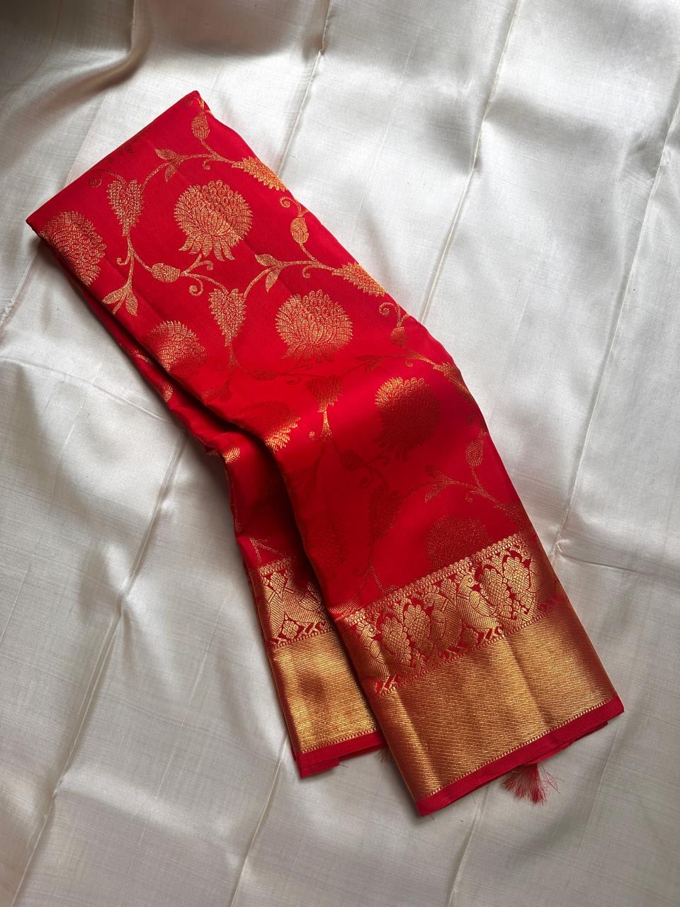 Tanvi – Vermillion Red Kanchipuram Pure Silk Saree with Floral Zari Jaal & Baavanji Border
Bold, radiant, and intricately woven varisaipettu Pallu